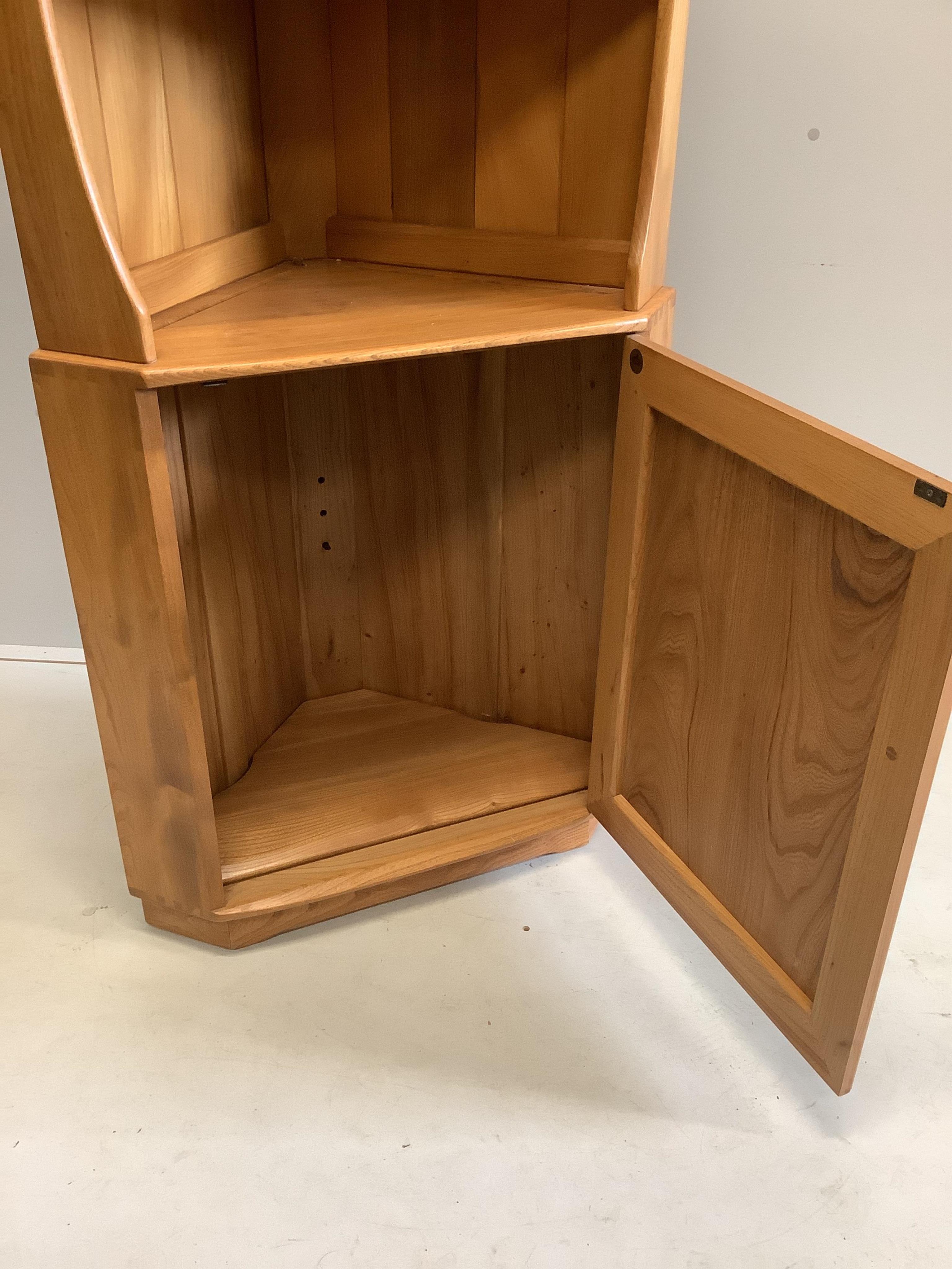 An Ercol elm standing corner cabinet, width 72cm, depth 41cm, height 179cm